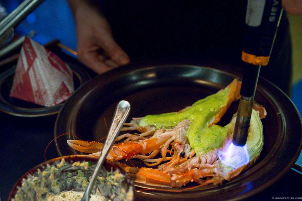 After a few minutes in the Green Egg grill, the tarragon butter is applied and heated with a cooking torch