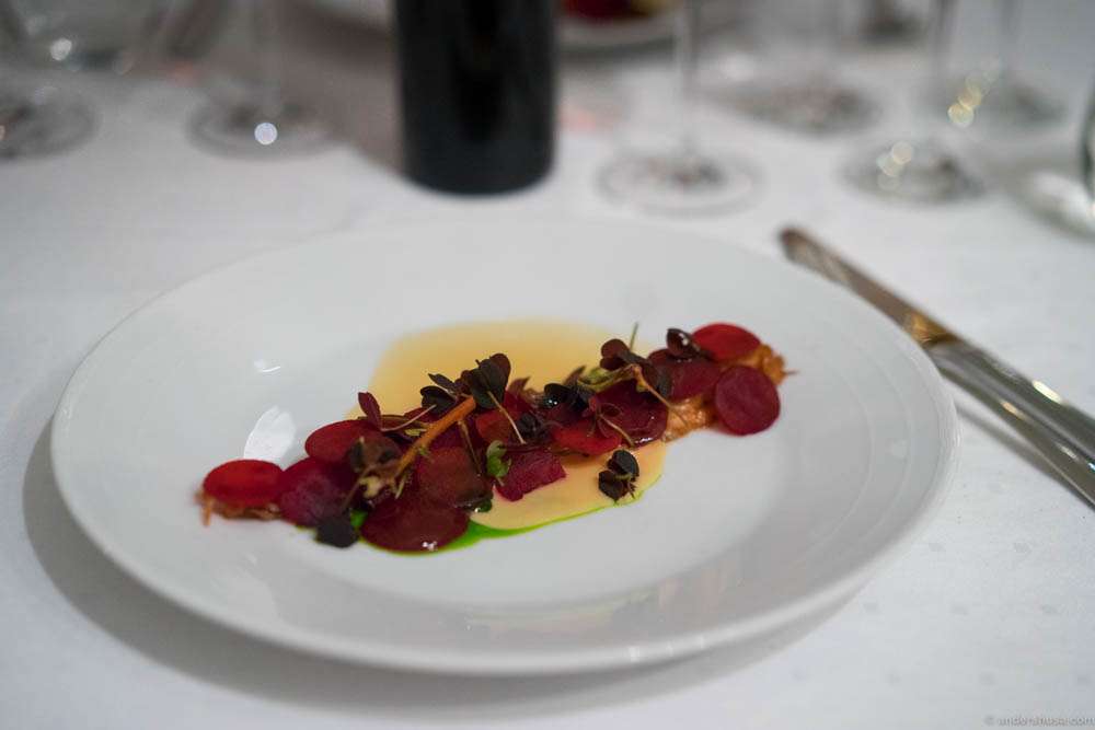 Braised pig tails with raw and pickled beets, chokeberry cream and chives oil