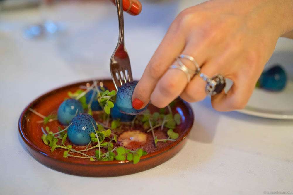 Danish "Sol æg". Quail egg, cooked and pickled in red cabbage juice, served with mustard cream, mustard spices and powder of dried red cabbage
