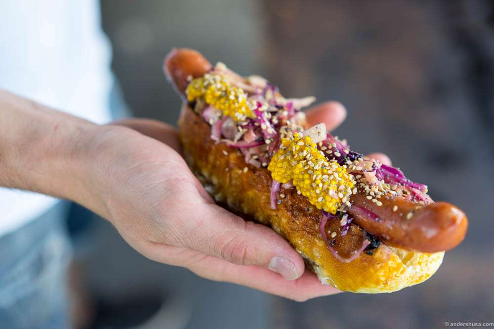 Spicy grill sausage in pretzel bread with homemade mustard and cabbage salad