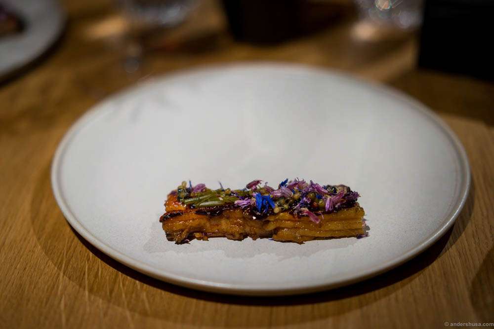 Fire roasted pork belly, black garlic, blackcurrant and salted flower buds at restaurant Kadeau in Copenhagen, Denmark