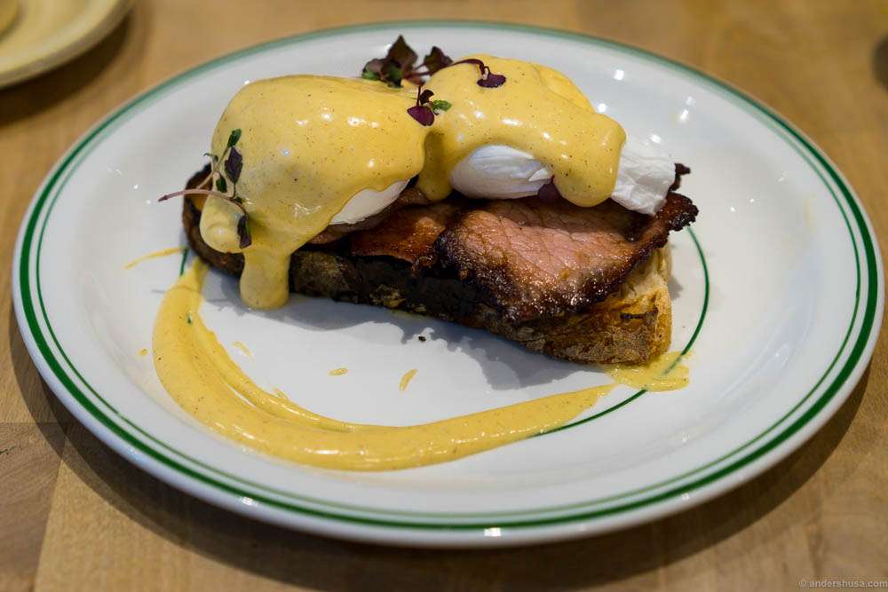 Sourdough bread, smoked bacon, poached eggs and browned butter hollandaise at restaurant Milk in London, UK.
