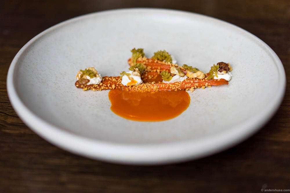 Dehydrated carrots rehydrated in their own juice, pickled orpin flowers, sour curd & concentrated carrot juice with browned butter at restaurant Amass in Copenhagen, Denmark