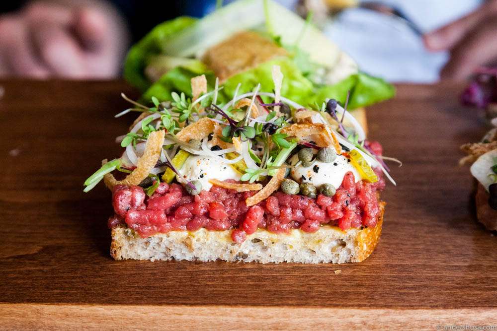 Beef tartare, fresh cheese, capers, pickled cucumbers, raw & crispy onions on sourdough