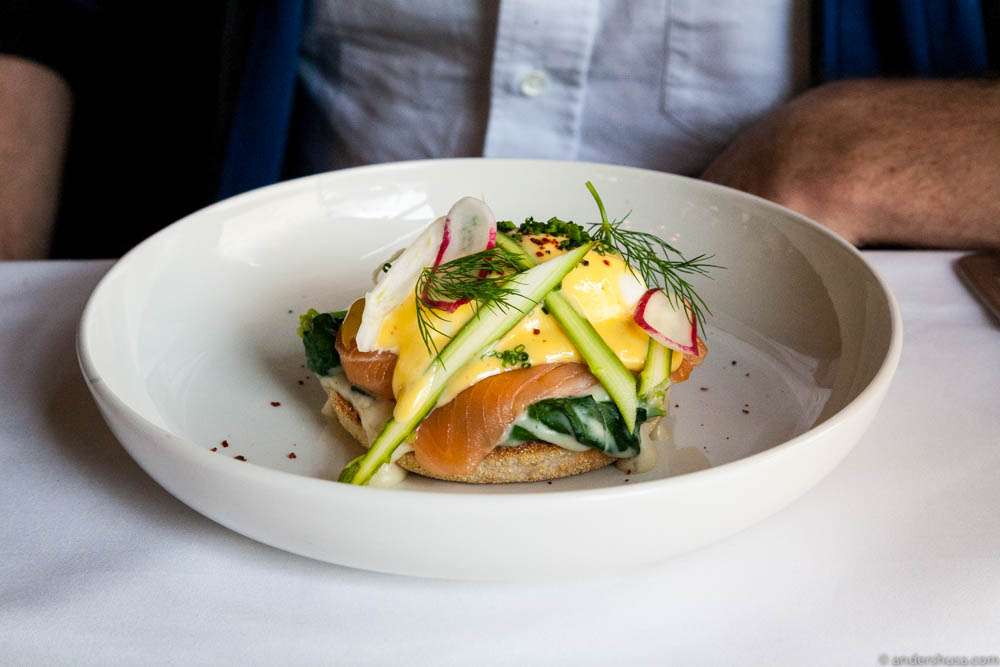 Egg Royal with smoked salmon, creamy spinach, crudité of asparagus and radish & hollandaise sauce on an English muffin