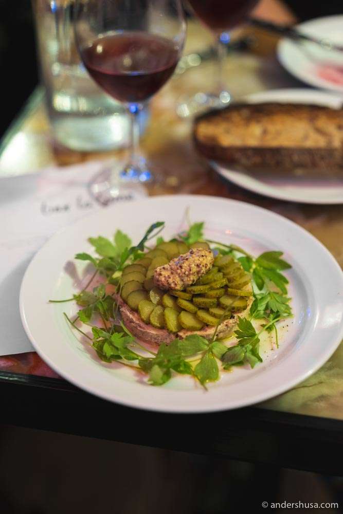 Pork fat and duck liver rillette with pickles on toasted bread.