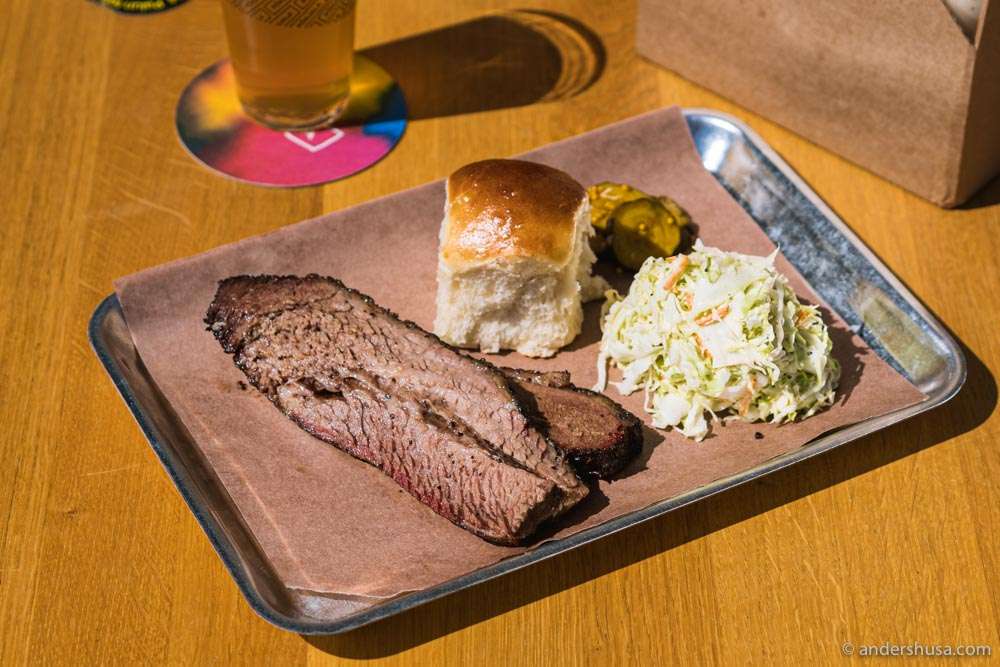 Slabs of brisket with a Parker House roll, coleslaw, and pickles.