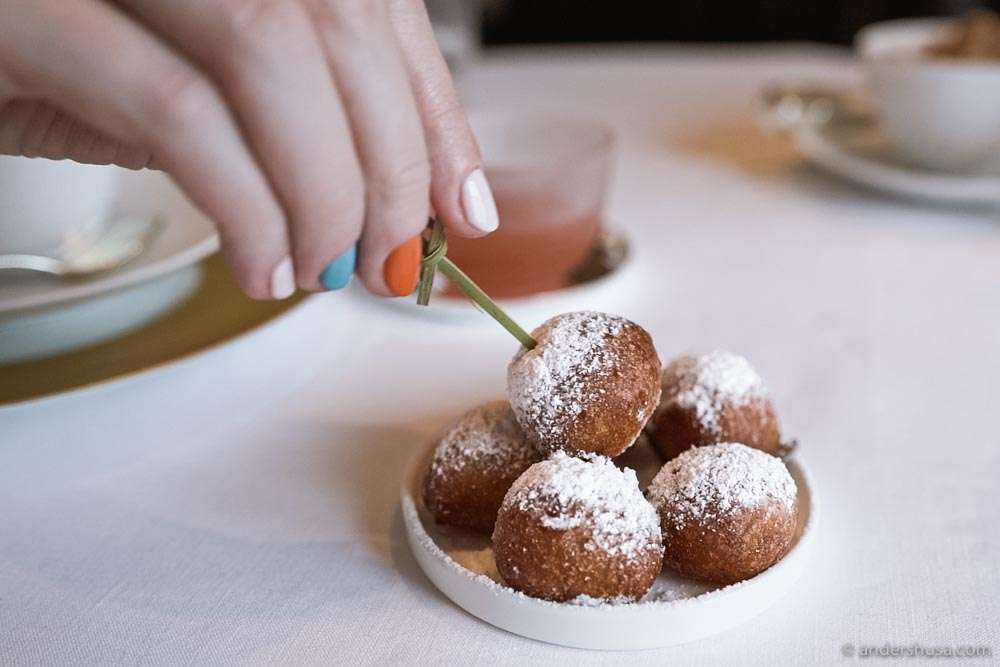 A pile of beignets dusted with powdered sugar.