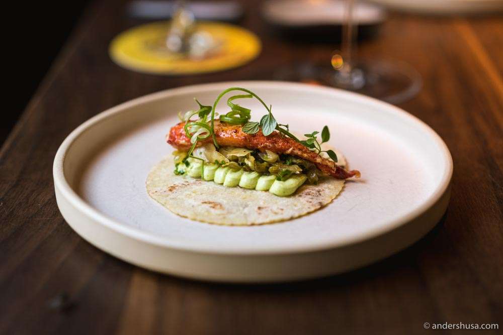 The king crab taco served in a potato lompe with chive cream cheese, lemon thyme, and spring onion.