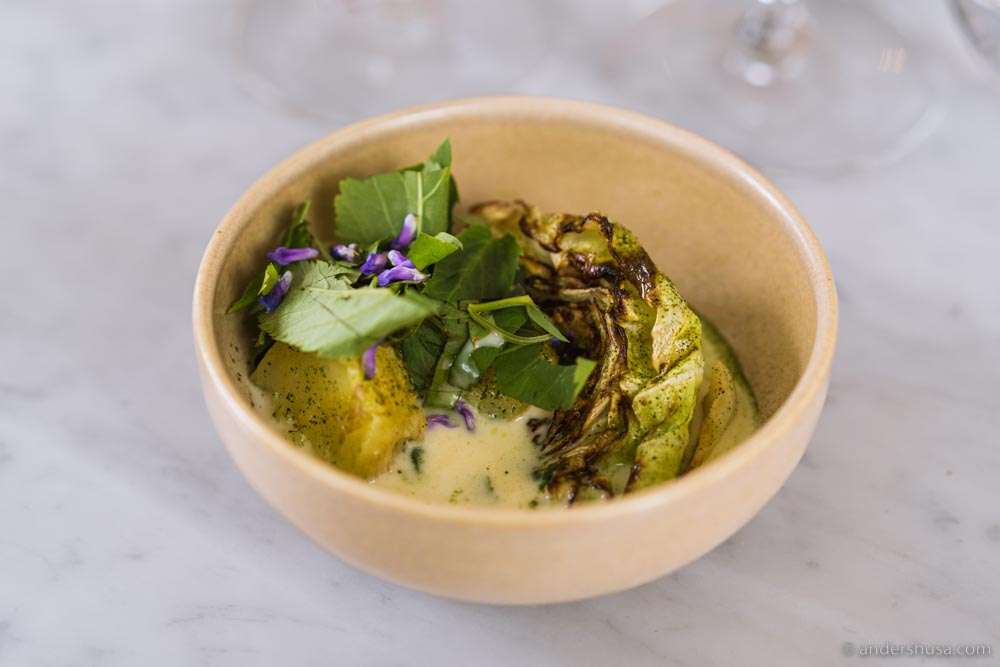 Grilled cabbage with potatoes, whey sauce, nettles, and lovage.