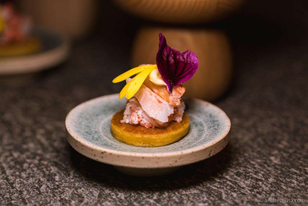 Potato lompe, aquavit butter, langoustine claw, ginger, chili, & flowers.