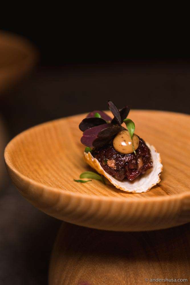 Crispy milk skin taco, cow tartare, lovage, cep, juniper gel, & sorrel leaves.